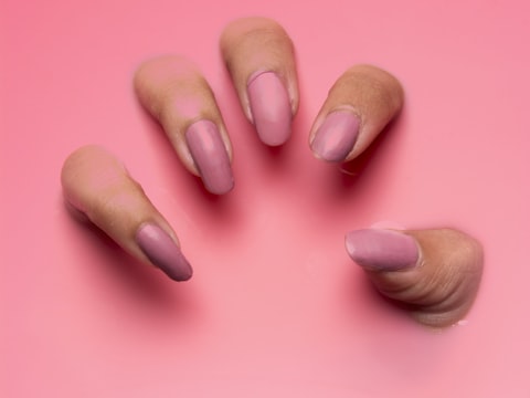 Tubo de crema de manos de karité sobre fondo rosa suave